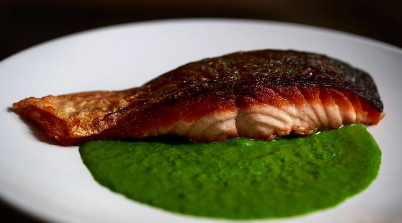 Hillel Echo-Hawk prepares her salmon dish with a dandelion and honey puree. Her catering/private-chef company, Birch Basket, focuses on indigenous-based, pre-colonization foods. (Erika Schultz/Seattle Times/TNS)