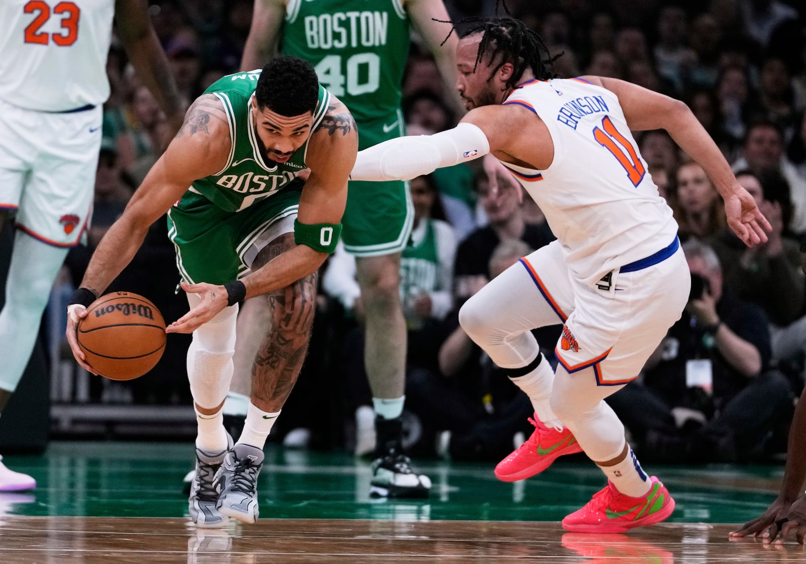 Boston Celtics forward Jayson Tatum, left, grabs a loose ball against New York Knicks guard Jalen Brunson (11) during the first half of Game 2 of an NBA basketball second-round playoff series, Wednesday, May 7, 2025, in Boston. (AP Photo/Charles Krupa)