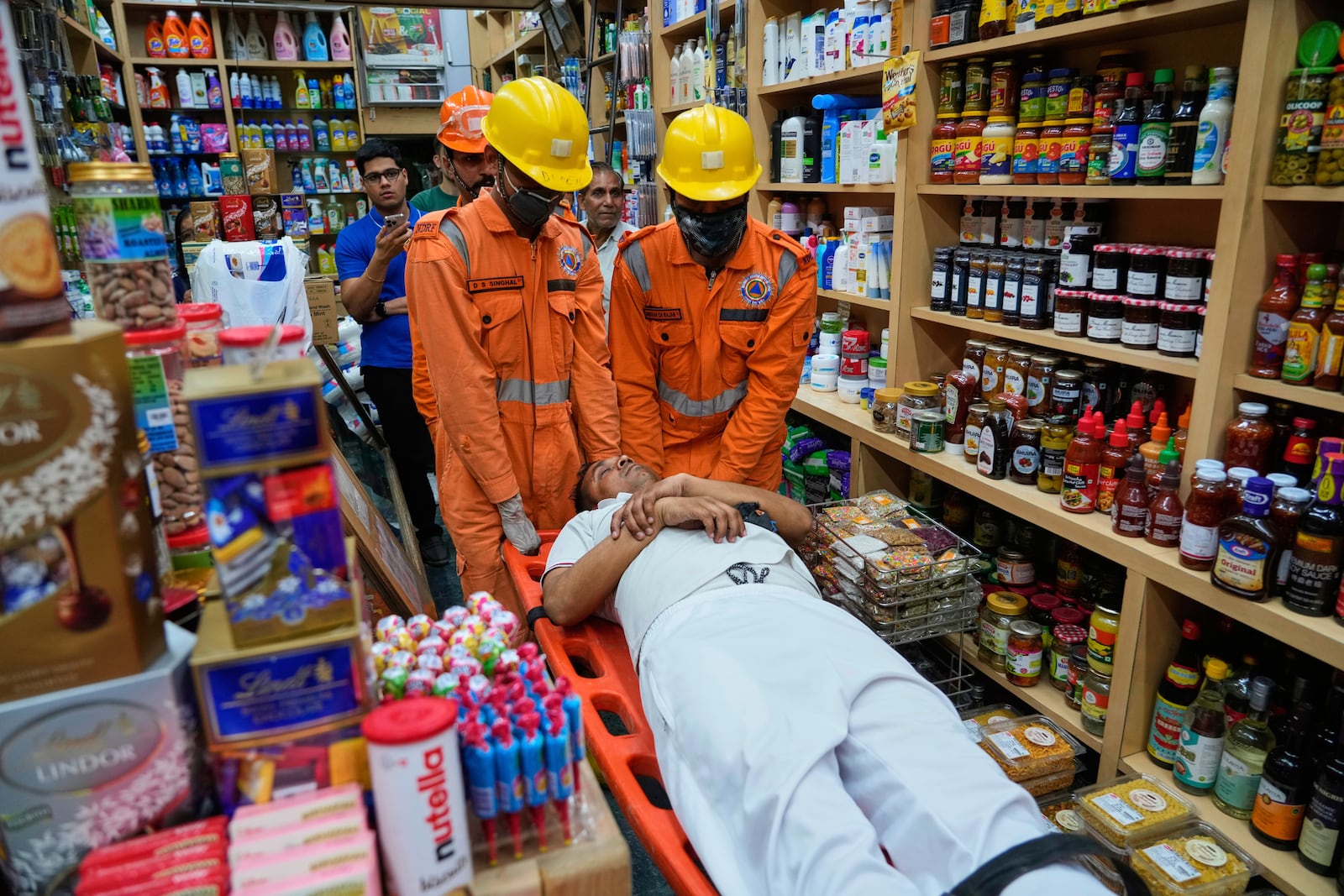 National Disaster Response Force team members carry out a mock drill in a market to train civilians and security personnel to respond in case of attack, in New Delhi, India, Wednesday, May 7, 2025. (AP Photo/Manish Swarup)