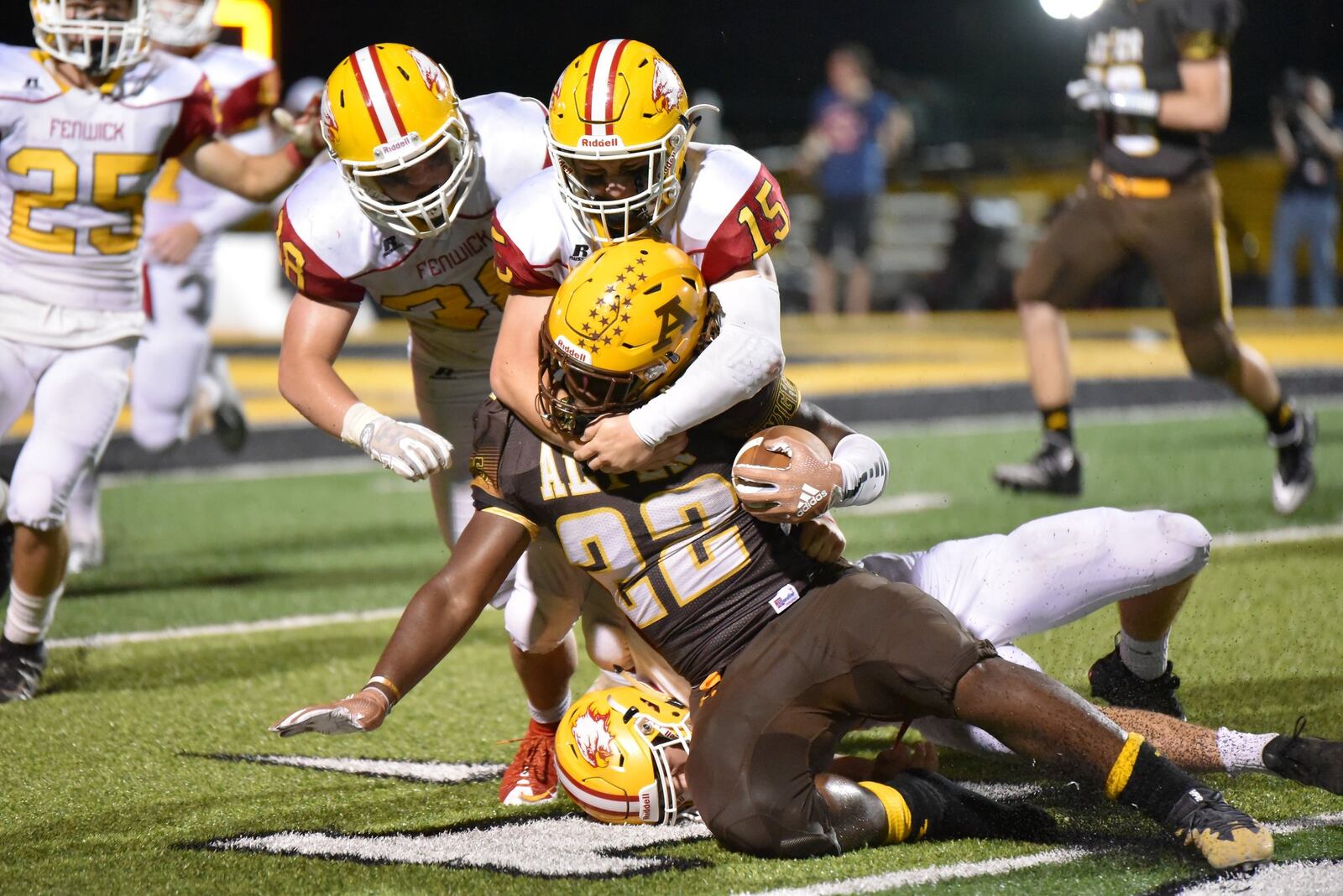 It takes three Fenwick defenders — Henry Nenni (15), John Stevenson (38) and Logan Miller (26, bottom) — to bring Alter’s Branden McDonald (22) down during Friday night’s game at Centerville Stadium. McDonald scored three touchdowns in the Knights’ 45-20 win. CONTRIBUTED PHOTO BY ANGIE MOHRHAUS