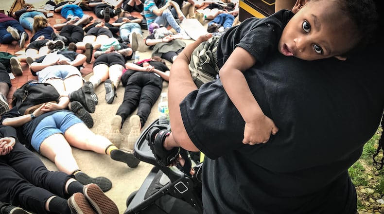 Fairborn resident Syrita Nuttall holds her 1-year-old son Jalen Highsmith during a protest for George Floyd on Main Street Thursday afternoon. JIM NOELKER/STAFF