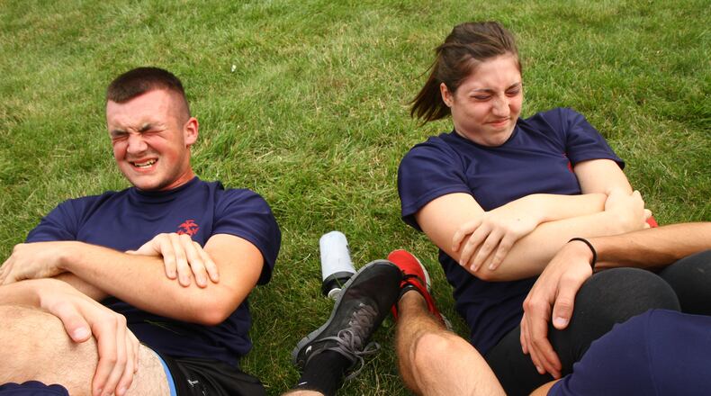 Marine recruits Cameron Diviak, 18, and Vanessa Summers, 18, attempt to do as many sit-ups as possible in two minutes while working out at the Armed Forces recruiting center on North Limestone Street in Springfield on Wednesday, July 3, 2013. The service branches and U.S. Special Operations Command recently released plans for implementing women into previously closed combat positions. But, now that women will soon be allowed into close combat, should they also have to register for the draft? Since 1980, the Selective Service System has required only men, ages 18 to 25, to register with the government in the event of a military draft. Barbara J. Perenic/Staff