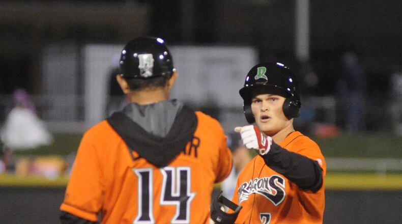 Brantley Bell (right) is congratulated by Dragons manager Luis Bolivar after a run-scoring triple in the second inning of the second game against the Lake County Captains at Dayton’s Fifth Third Field on Friday, April 7, 2017. MARC PENDLETON / STAFF