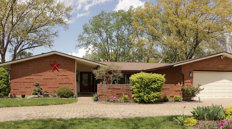 The 4-bedroom ranch home offers about 3,160 sq. ft. of living space with a finished basement with a recreation room. A paver-brick driveway circles the front yard, providing double street access to the 2-car garage. The paver brick extends from the drive into a walkway that leads to the formal entry. A brick wall creates a courtyard setting with mini gardens and a koi pond with water feature. CONTRIBUTED PHOTO BY KATHY TYLER