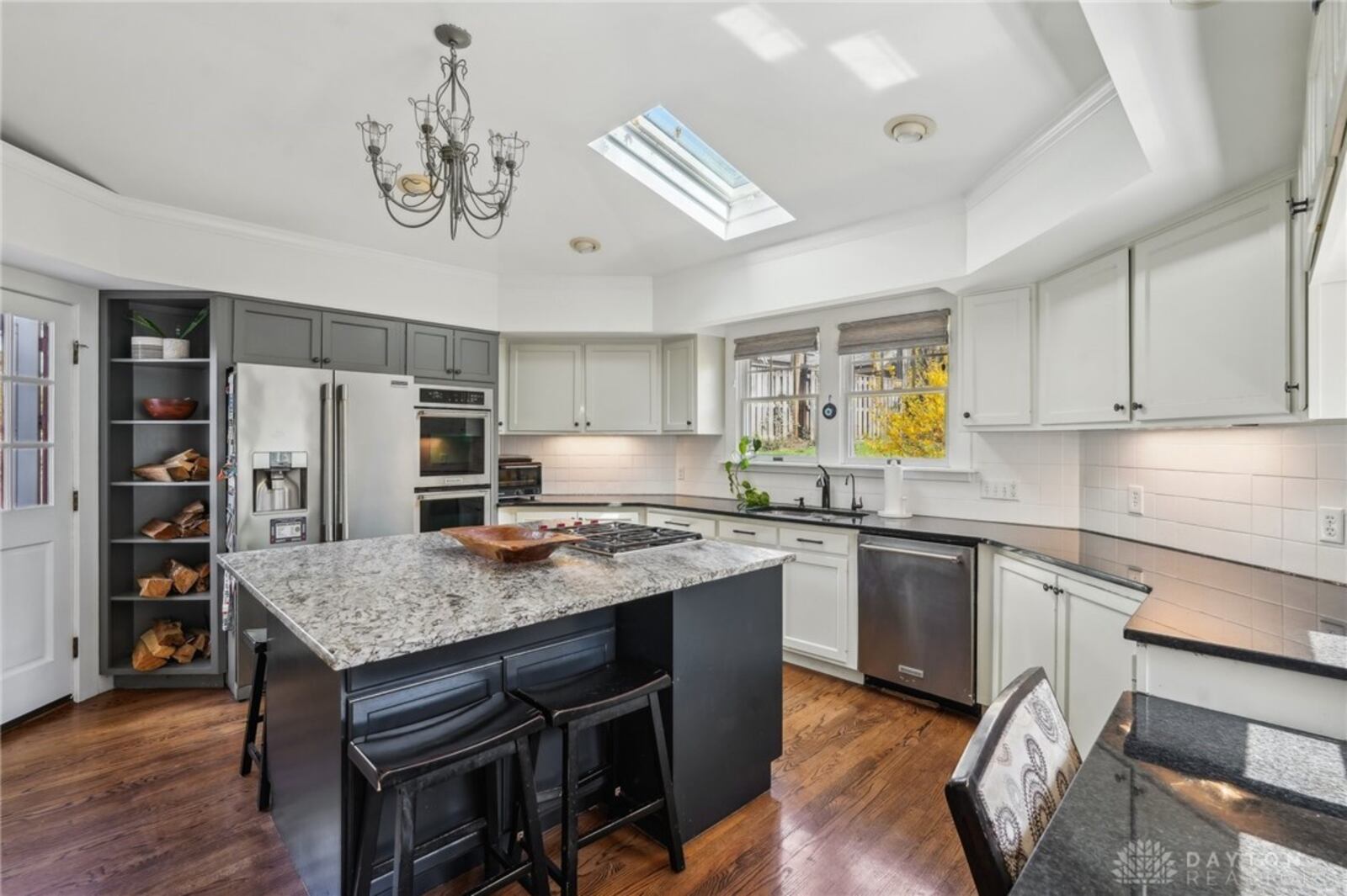 The updated kitchen has newer appliances, a gas cooktop in the island and hardwood floors.