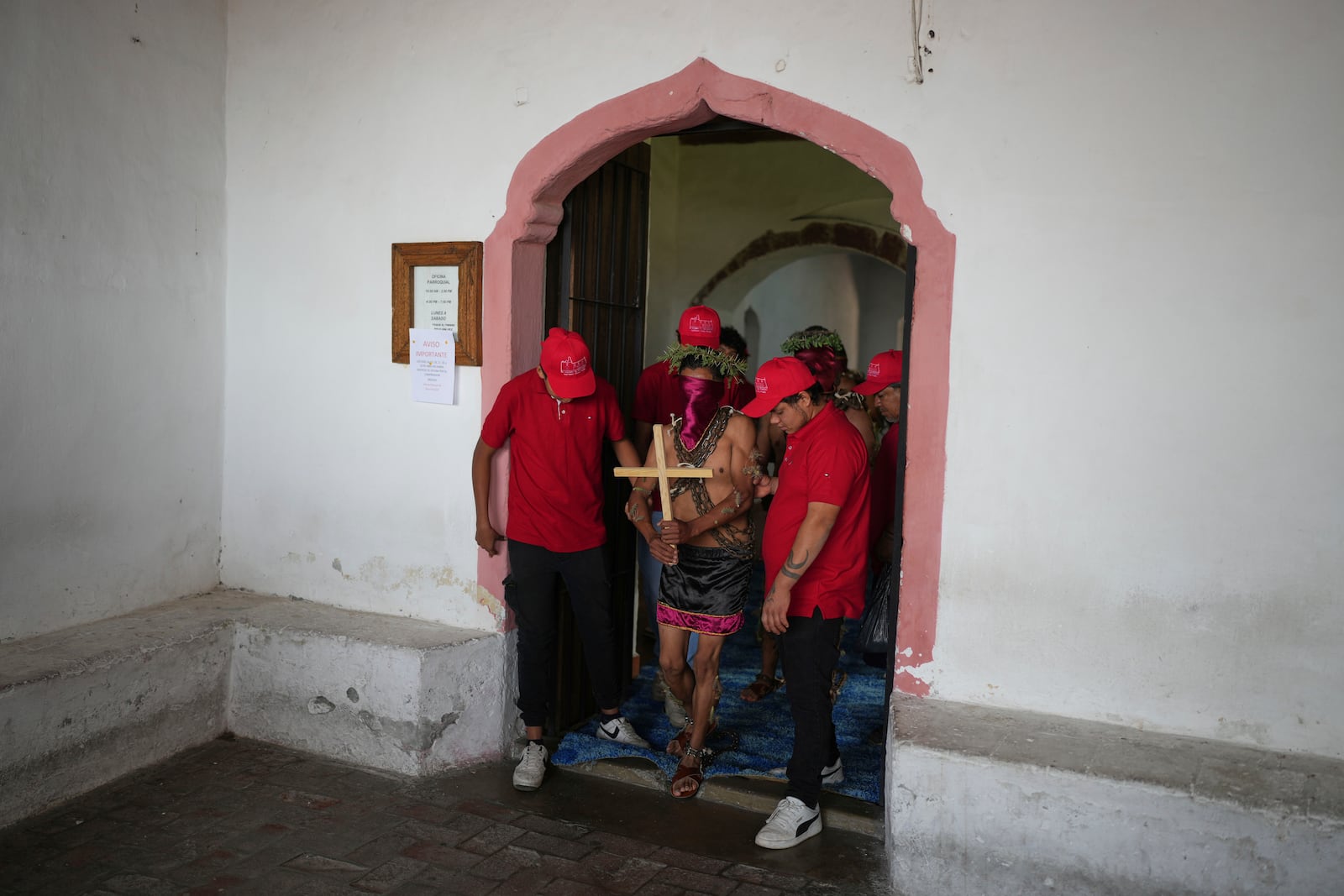 A masked penitent in chains is led to take part in a Holy Week procession in Atlixco, Mexico, on Good Friday, April 18, 2025. (AP Photo/Eduardo Verdugo)
