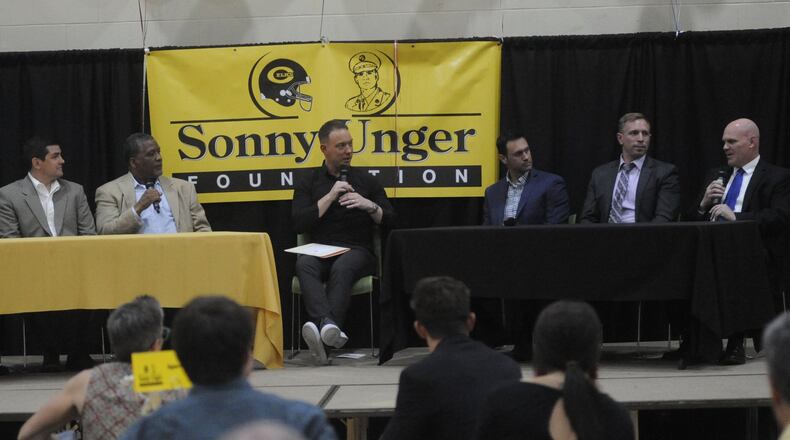 GWOC football coaches Jay Minton (Wayne, left), Nic Black (Beavercreek), Jeff Graham (Trotwood-Madison), emcee Ryan Hawk, Ryan Wilhite (Springboro), Brent Ullery (Centerville) and Dave Miller (Fairmont) discuss a wide range of topics during the Sonny Unger Memorial Scholarship banquet at Fairhaven Church in Centerville on Tuesday, May 8, 2018. The foundation honors the memory of 1963 Centerville High School graduate Lester “Sonny” Unger, 22, who was killed during the Vietnam War in 1966. STAFF FILE PHOTO