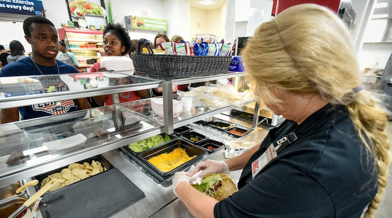 Cafeteria Manager Terry Mueller prepares a burrito Sept. 21 for a student at Lakota East Freshman School in Liberty Twp. Terry Mueller — a 22-year veteran of Lakota meal services — has seen the pre-packaged trend first hand and welcomes it. Terry Mueller — a 22-year veteran of Lakota meal services — has seen the pre-packaged trend first hand and welcomes it. “We did make a lot of things from scratch before that are now pre-cooked so we’re doing a heat and go. But things now are healthier,” said Mueller, citing the wider range of fruits, vegetables and lean meats, lower in fat and calories.