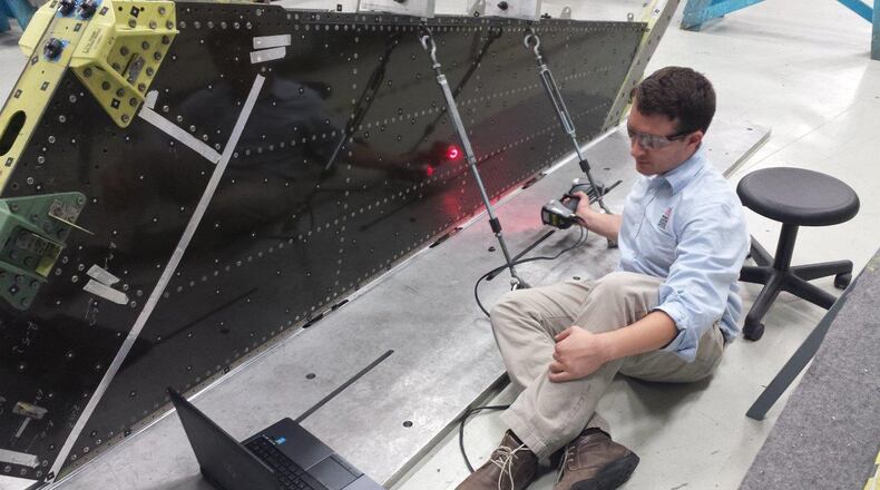 Solomon Duning, research engineer, University of Dayton Research Institute, uses laser scanning technology to inspect an F-16 vertical tail on a depot fixture. (U.S. Air Force photo)