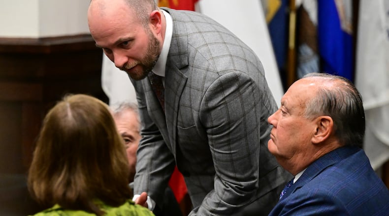 Attorney Noah Munyer, center, talks with attorney Carole Rendon, as former FirstEnergy Corp. CEO, Chuck Jones, right, sits inside the courtroom at the Summit County courthouse in Akron, Ohio, on Tuesday, Feb. 13, 2024. Two fired top executives of FirstEnergy Corp. and Ohio’s former top utility regulator have pleaded not guilty in connection with a $60 million bribery scheme. (AP Photo/David Dermer)