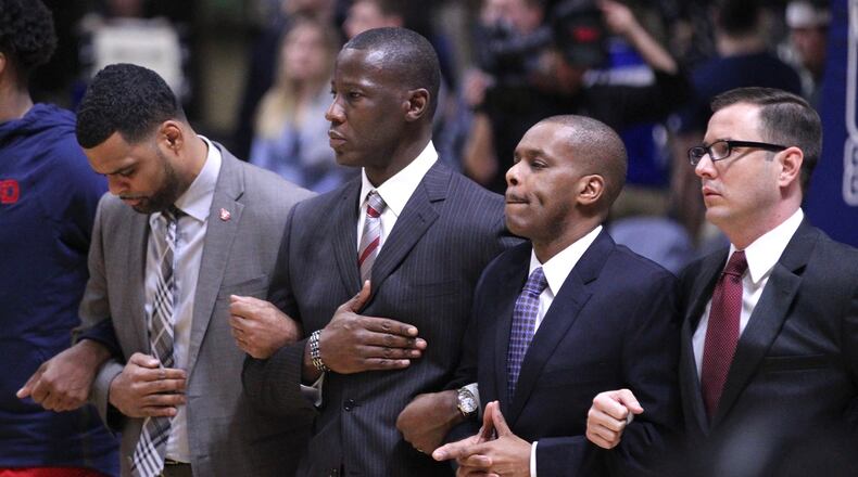 Dayton coaches (left to right) Ricardo Greer, Anthony Grant, Anthony Solomon and James Kane stand for the national anthem before a game against Rhode Island on Friday, Feb. 23, 2018, at the Ryan Center in Kingston, R.I. David Jablonski/Staff