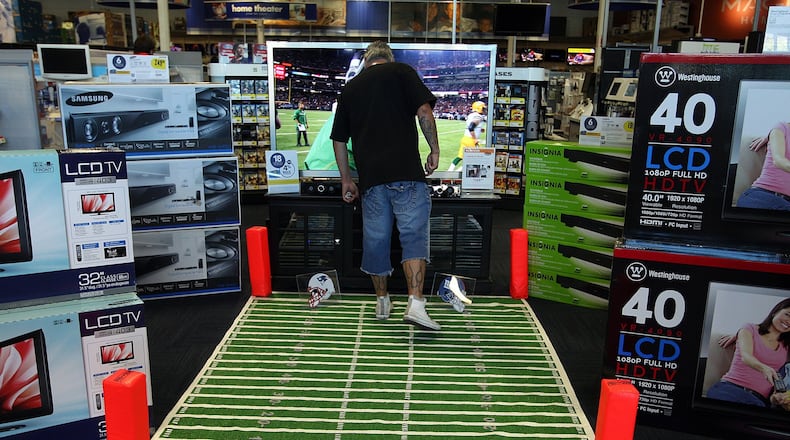 TV shopper David Trevino looks at a 65” Samsung television showing a previous Super Bowl at a Best Buy electronics store in Burbank, Calif., on February 1, 2012. There are a few factors to think about before you buy a new flatscreen. (Gary Friedman/Los Angeles Times/TNS)
