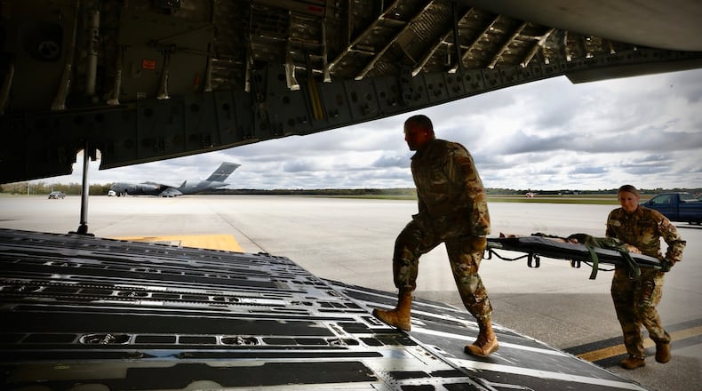 Crewmembers of a C-17 Globemaster III load dummies onto the aircraft during a mock medical evacuation drill at Wright Patterson Air Force Base, Wednesday, October 16, 2024. MARSHALL GORBY \STAFF