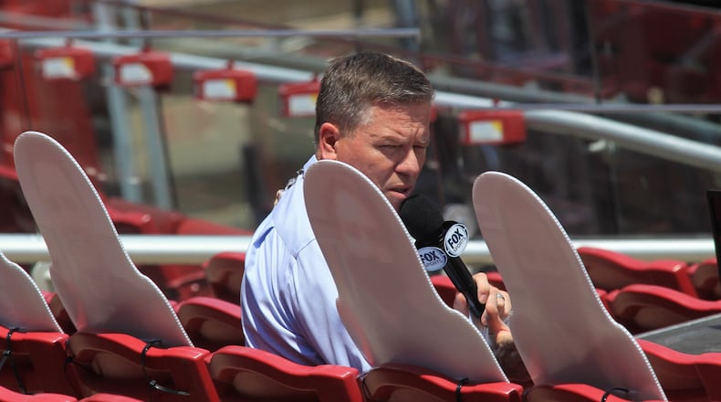 Jim Day, of Fox Sports Ohio, looks at four cardboard cutouts of fans in the stands during a game between the Reds and Tigers on Sunday, July 26, 2020, at Great American Ball Park in Cincinnati. David Jablonski/Staff