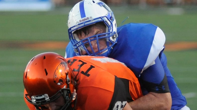 Beavercreek QB Jacob Maloney (front) is ridden down by Xenia’s Ken Klontz. Beavercreek hosted Xenia in a season-opening high school football game on Thursday, Aug. 25, 2016. MARC PENDLETON / STAFF