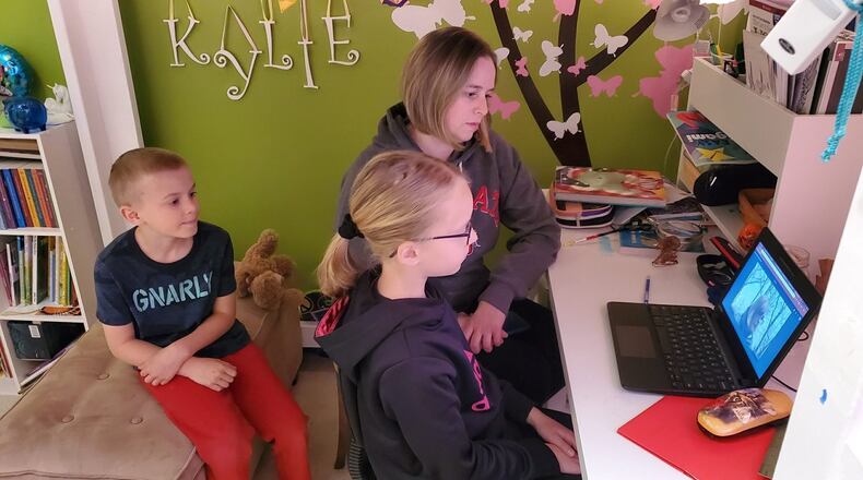 Wade Bennett, grade 1, with sister Kylie Bennett, grade 4, with mother, Megan Bennett, tune-in for the reading of a chapter of “Wishtree”. CONTRIBUTED