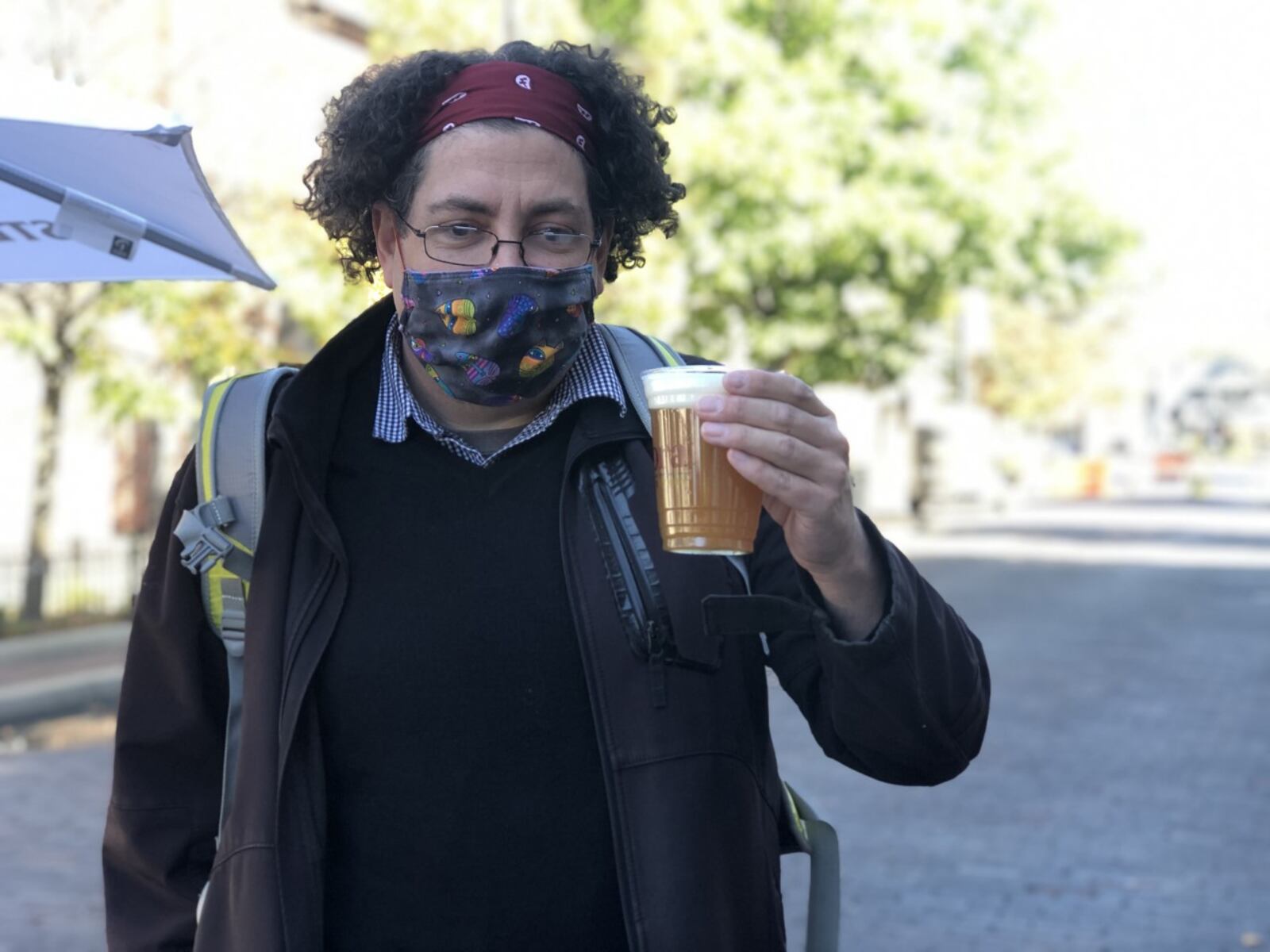 David Watkins carries a beer in the Oregon District's outdoor drinking area. CORNELIUS FROLIK / STAFF