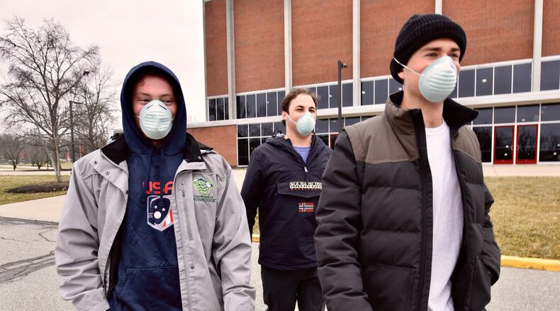 Miami students, left to right, Brian Coan, Matt Reinberg and Jack Kulick wear face masks as they walk across campus Tuesday, Jan. 28, 2020, in Oxford. NICK GRAHAM / STAFF