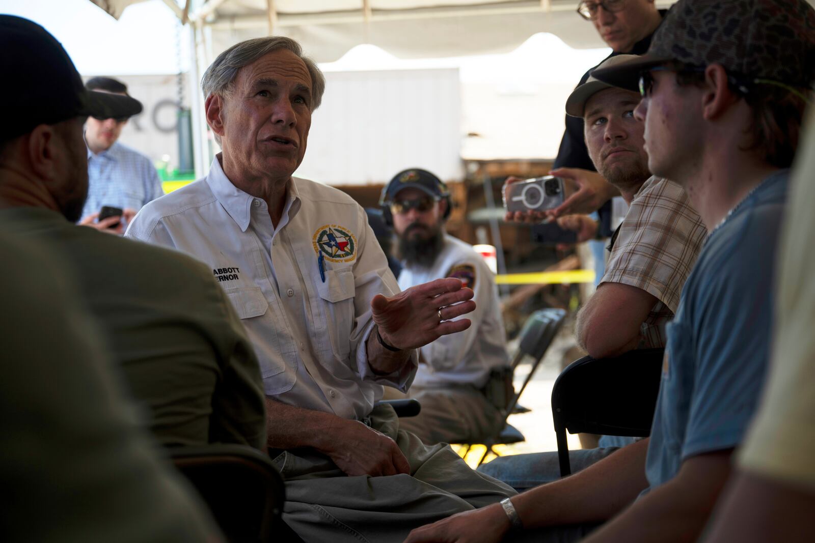Texas Gov. Greg Abbott speaks to residents and volunteers before a press conference on Tuesday, July 8, 2025, in Hunt, Texas. (AP Photo/Eli Hartman)