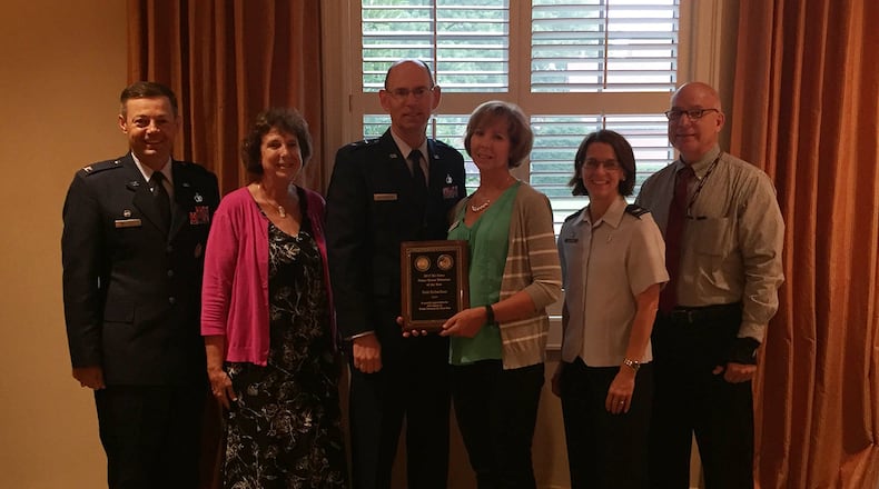 Joining 2017 Air Force Fisher House Volunteer of the Year Dede Richardson (center) Aug. 7 to celebrate her accomplishment were (left to right): Col. Bradley McDonald, 88th Air Base Wing commander; Karen Healea, Fisher Houses manager; Maj. Gen. Duke Richardson, Air Force program executive officer for Presidential Airlift Recapitalization, Air Force Life Cycle Management Center; Col. Shari Silverman, 88th Medical Group commander; and Dan Druzbacky, 88 MDG compassionate care manager. The award ceremony was held at the Fisher House II, one of two, side-by-side compassionate comfort care facilities at Wright-Patterson Air Force Base. (Skywrighter photo/Amy Rollins)