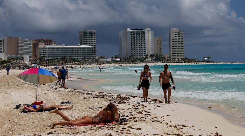 FILE - Tourists sunbathe on the beach before the arrival of Hurricane Grace, in Cancun, Quintana Roo State, Mexico, Aug. 18, 2021. (AP Photo/Marco Ugarte, File)