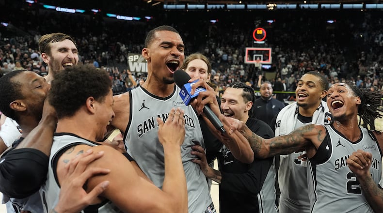 San Antonio Spurs forward Victor Wembanyama, center, celebrates with teammates after he hit a game-winning score against the Phoenix Suns in the final seconds of an NBA basketball game in San Antonio, Thursday, March 19, 2026. (AP Photo/Eric Gay)