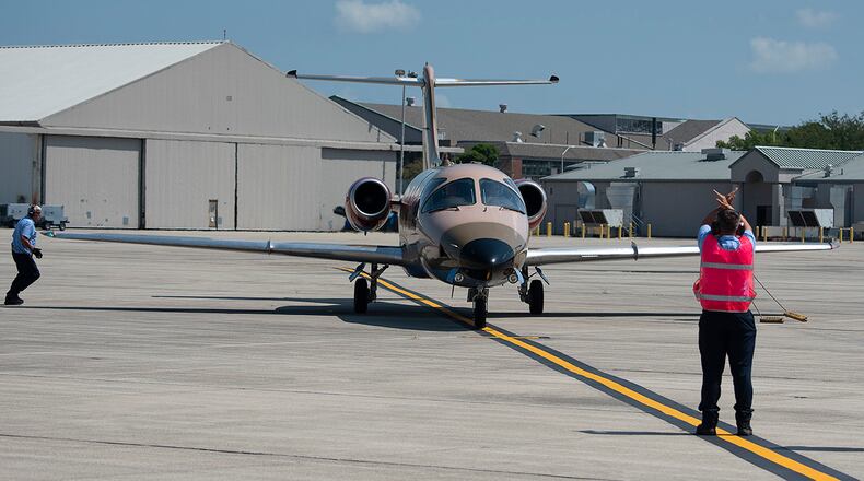 Contractors with the 88th Logistics Readiness Squadron’s Transient Alert Office marshal an Air Force T-1 Jayhawk aircraft belonging to the 48th Flying Training Squadron from Columbus Air Force Base, Mississippi, into its parking spot Aug. 27 at Wright-Patterson Air Force Base. Seven planes with 48 FTS, on a training flight to Michigan, stopped at Wright-Patterson for fuel. U.S. AIR FORCE PHOTO/R.J. ORIEZ