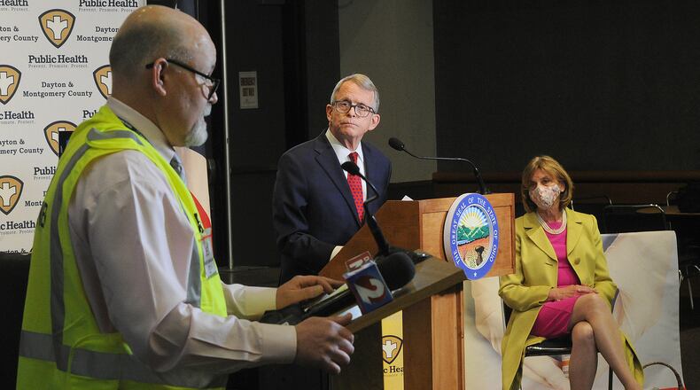 Jeff Cooper, health commissioner for Public Health Dayton Montgomery County, talks with Ohio governor Mike DeWine and first lady Fran DeWine at the Dayton Convention Center Thursday, April 1, 2021. MARSHALL GORBY\STAFF