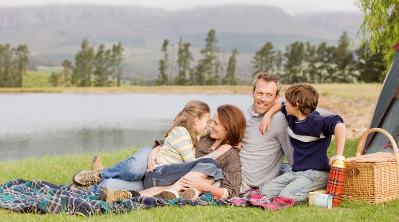 A family enjoys summer time next to a lake. PAUL BRADBURY/ISTOCK
