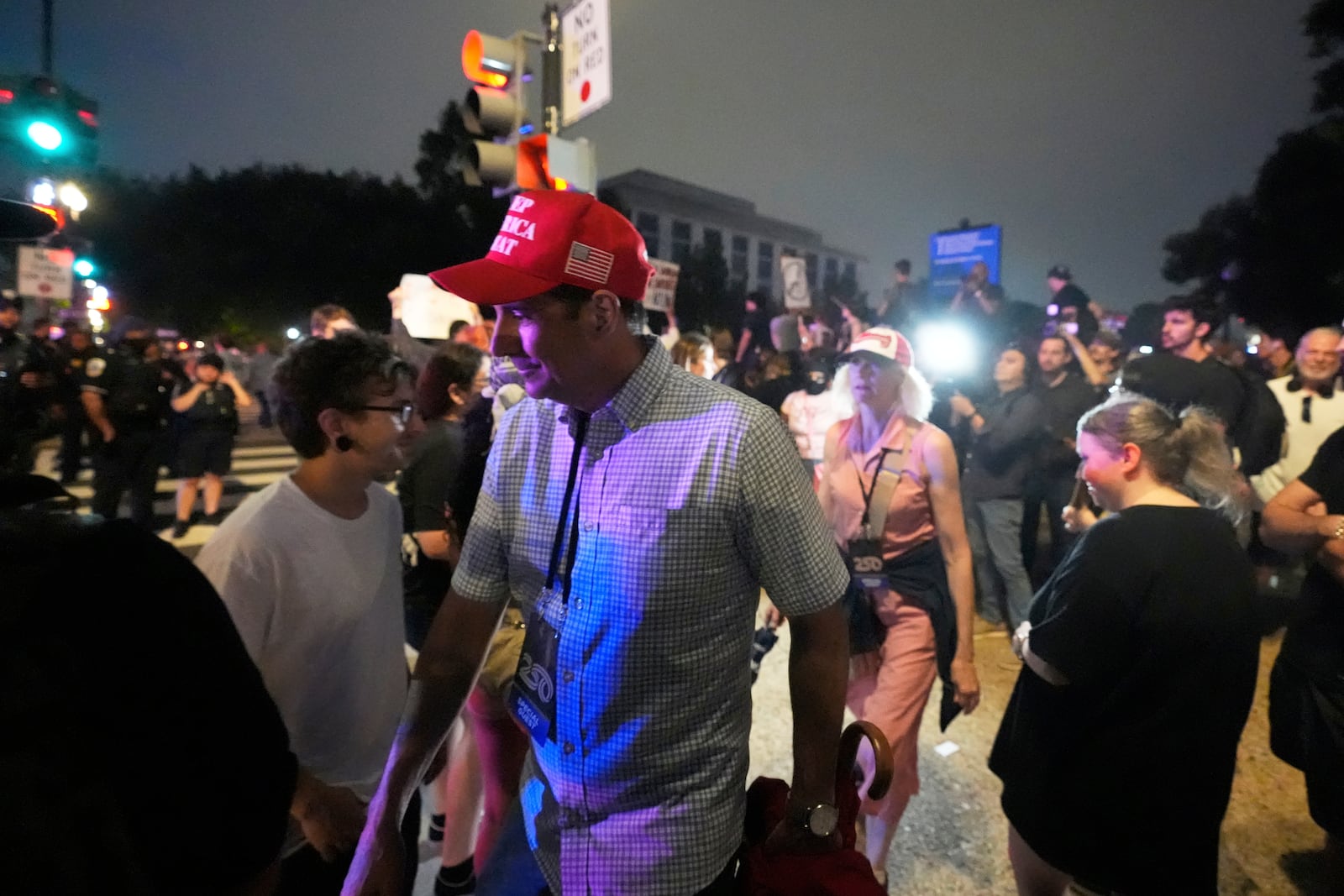 Supporters of President Donald Trump depart a military parade commemorating the Army's 250th anniversary of the Army as they walk through demonstrators participating in protest taking place on the day of the parade, coinciding with President Donald Trump's 79th birthday, Saturday, June 14, 2025, in Washington. (AP Photo/Alex Brandon)