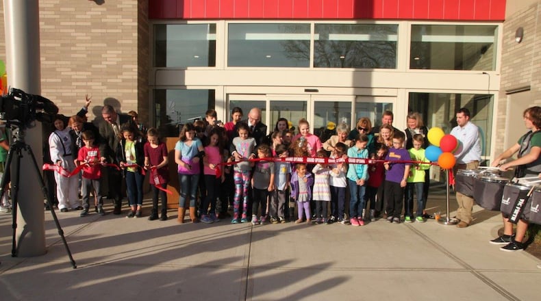 Tim Kambitsch, executive director of the Dayton Metro Library, invited children in the audience to assist him in the cutting of the ribbon. CONTRIBUTED
