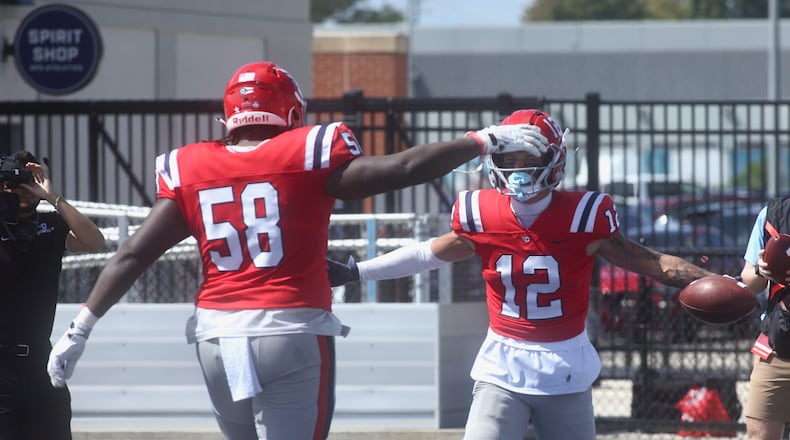 Dayton's Zachary McDowell, left, congratulates Gavin Lochow after a touchdown catch against Thomas More on Saturday, Sept. 6, 2025, at Welcome Stadium. David Jablonski/Staff