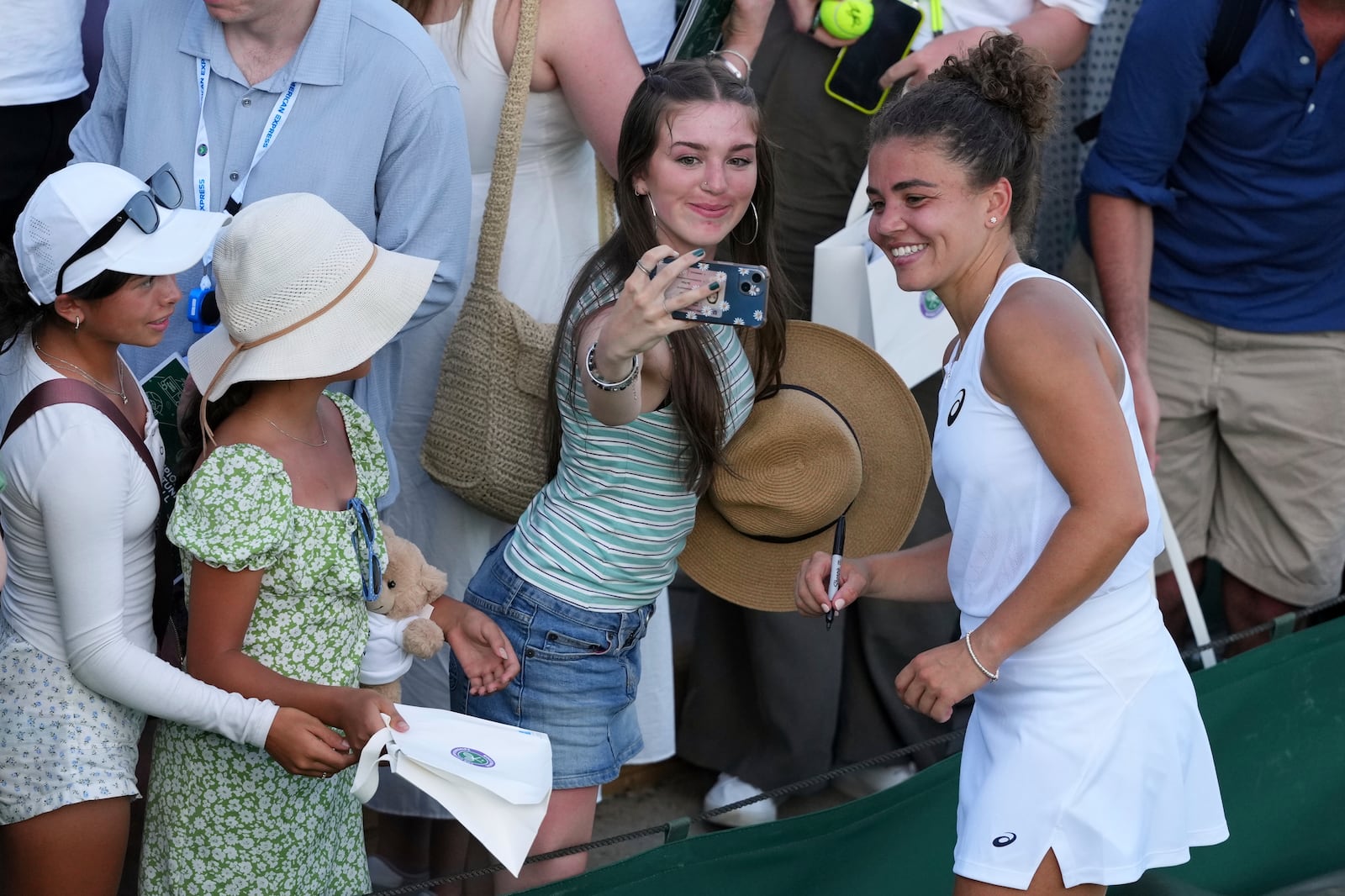 Jasmine Paolini of Italy poses for a photo with fans at the Wimbledon Tennis Championships in London, Monday, June 30, 2025. (AP Photo/Kirsty Wigglesworth)