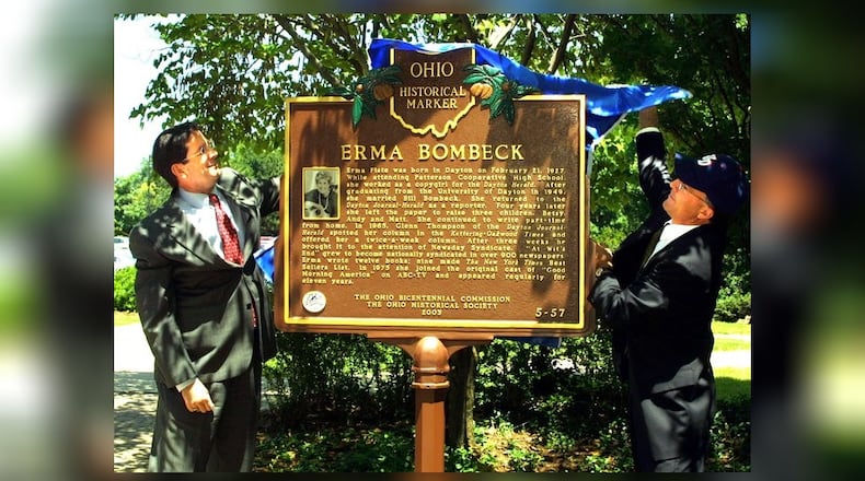 University of Dayton President Daniel Curran (L) and Lee Yoakum, deputy communications director for the Ohio Historical Society,unveil the Erma Bombeck historical marker on the walkway across from St. Mary's Hall on the University of Dayton campus friday as part of Reunion Weekend festivities. The two Miami Valley women are relatives (their husbands are first cousins to Erma). Erma Bombeck is a 1949 alumna of UD.