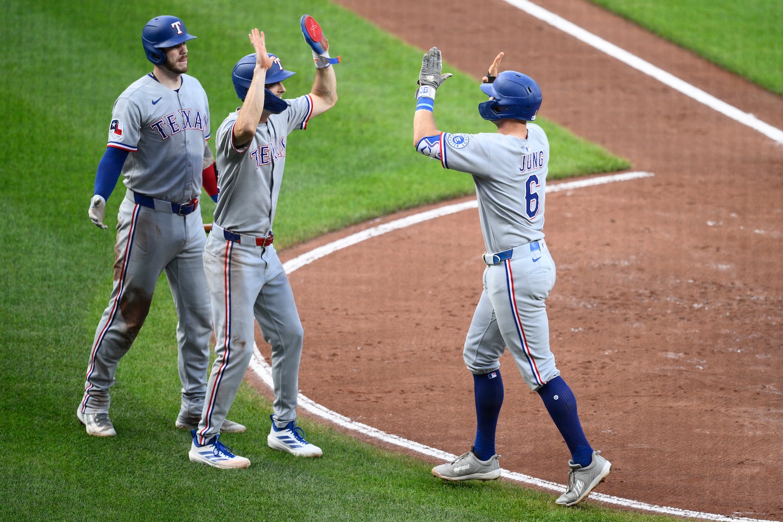 Texas Rangers' Josh Jung (6) celebrates his two-home run with Evan Carter, center, and Jonah Heim, left, during the fourth inning of a baseball game against the Baltimore Orioles, Wednesday, June 25, 2025, in Baltimore. (AP Photo/Nick Wass)