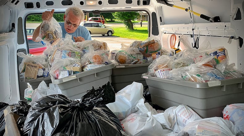 Ted Doggett, operations manager at the Greene County Public Library, loads up a library truck with food and snacks for kids. MARSHALL GORBY\STAFF