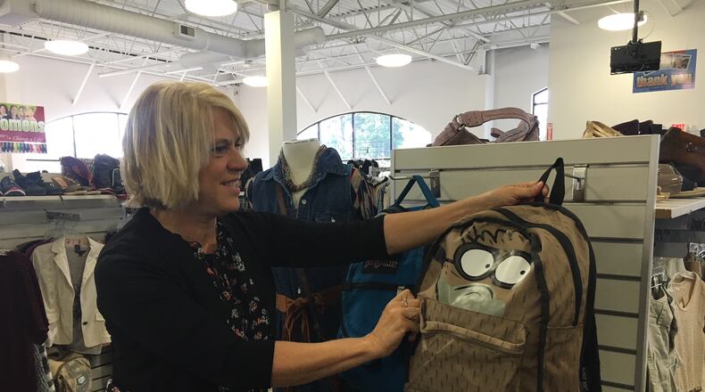Cindy Carusone, Goodwill Easter Seals Miami Valley public relations manager, shows off a backpack at the thrift store.