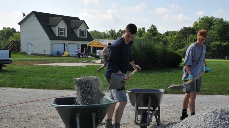 Air Force Academy Cadets Zack LaRocque and Evan Place load gravel into wheelbarrels to place in empty horse stalls at the Therapeutic Riding Institute July 6. The ground in some of the existing stalls was uneven, which can cause hoof problems with horses. LaRocque and Place were among a group of 20 cadets who travelled to Spring Valley, Ohio, July 6, to volunteer their day off to work around the institute’s new site, helping the institute prepare to begin operations at its new location. (U.S. Air Force photo/John Van Winkle)