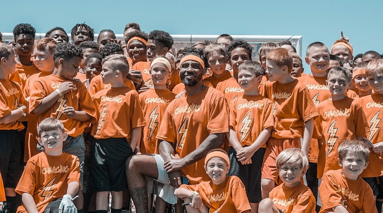 Wayne and Ohio State graduate Braxton Miller is shown with children from his CHARG1NG Camp. CONTRIBUTED