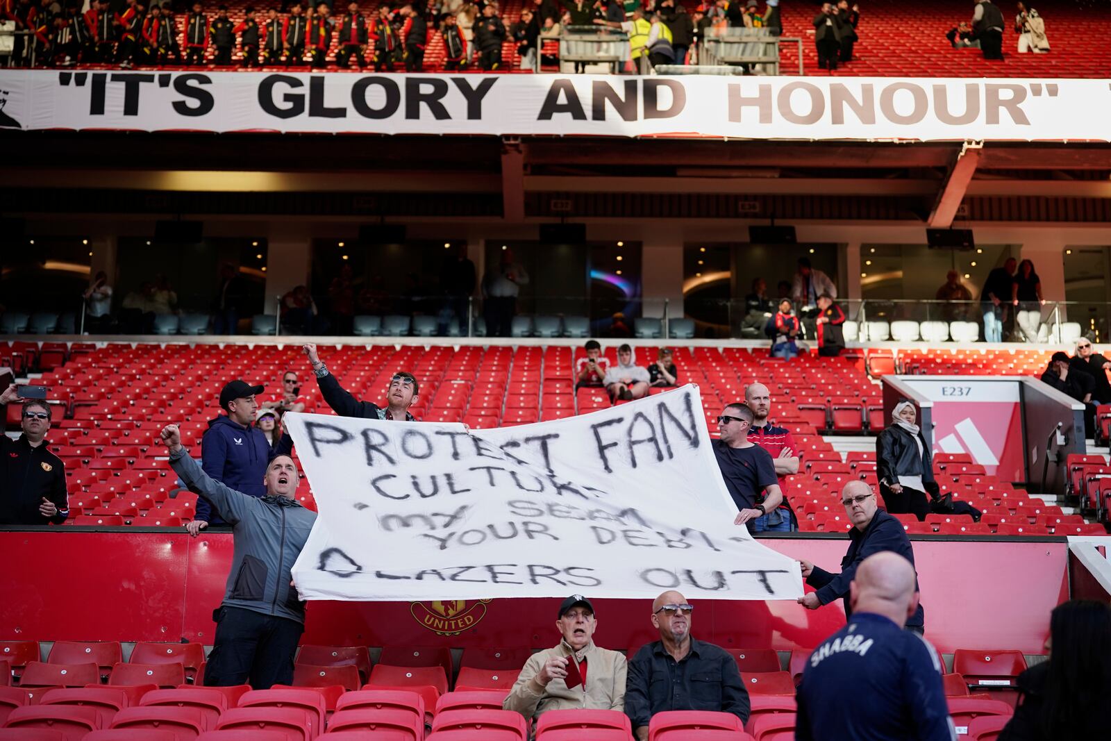 Mancheter United fans hold banners as they protest against the clunb's owners after the English Premier League soccer match between Manchester City and Manchester United in Manchester, England, Sunday, April 6, 2025. (AP Photo/Dave Thompson)