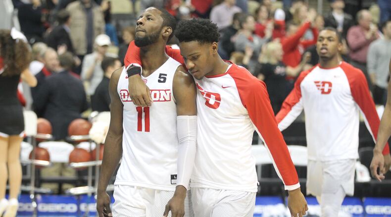 Dayton’s Scoochie Smith and John Crosby leave the court after a loss to Davidson on March 10, 2017, at PPG Paints Arena in Pittsburgh. David Jablonski/Staff