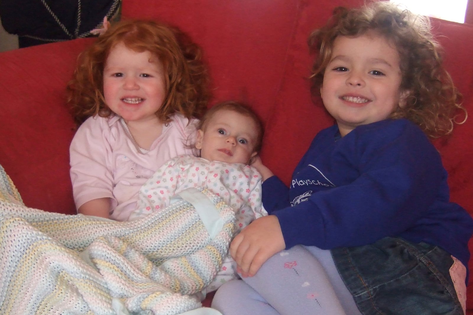 In this photo provided by the Lily Foundation, Rosie and Katie Merritt, of England, hold their sister, Lily, who died of a mitochondrial disease in 2006 at 8-months old. (Lily Foundation via AP)