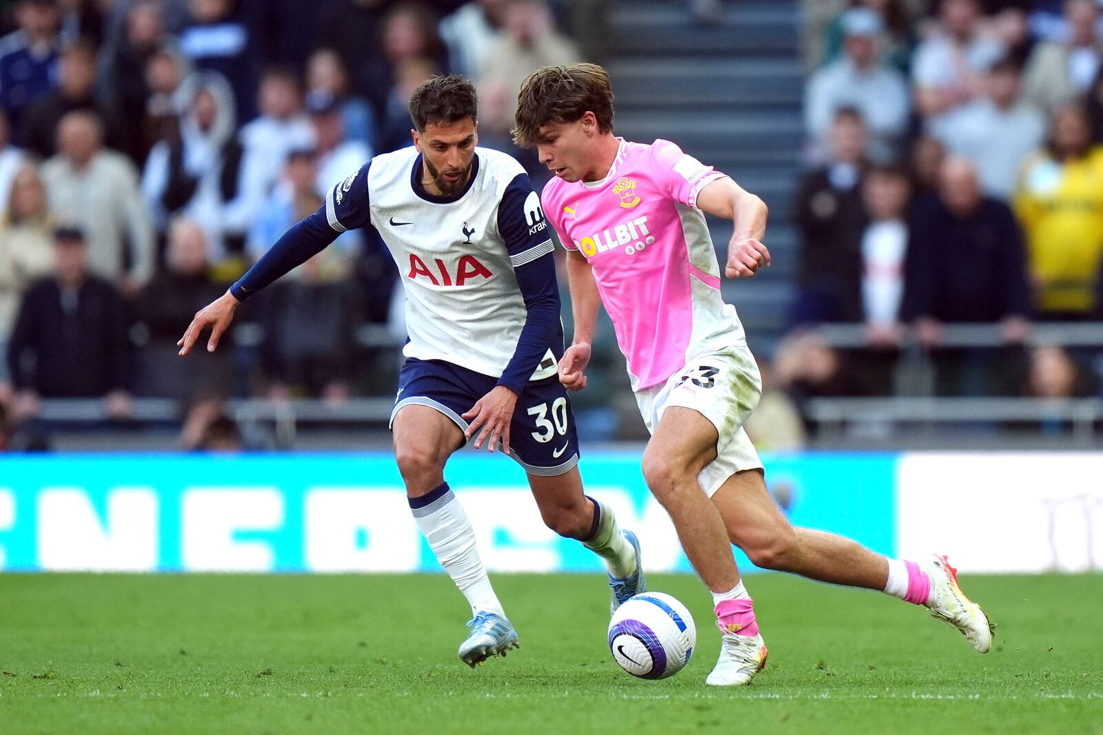 Southampton's Tyler Dibling, right and Tottenham Hotspur's Rodrigo Bentancur vie for the ball, during the English Premier League soccer match between Tottenham Hotspur and Southampton at Tottenham Hotspur Stadium, in London, Sunday April 6, 2025. (Bradley Collyer/PA via AP)