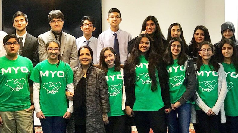 Muslim Youth Outreach (MYO) members shared their experiences with refugees and charity work on Dec. 1 at the Dayton Mercy Society in Miamisburg. Junior MYO members are pictured in the front row (green shirts), and MYO members are in the back row. Founder and coordinator Kaukab Husain is in the center of the front row. CONTRIBUTED