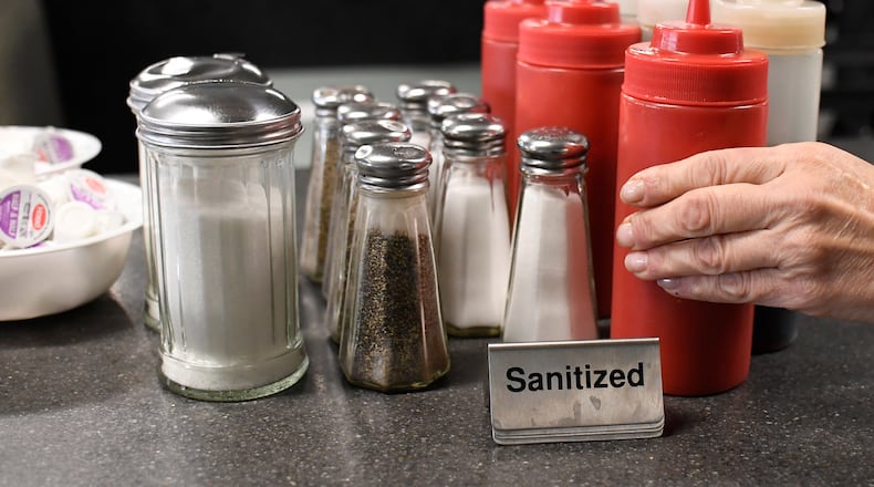 Head waitstaff Laurie Mitchell, places cleaned ketchup bottles together at Rodd's Restaurant, Thursday, Dec. 10, 2020, in Bristol, Conn. Small restaurant owners in Connecticut are taking out loans, forgoing their paychecks and charging on credit cards to remain in business as the coronavirus pandemic continues. But with winter putting an end to indoor dining and increased cases scaring off customers, some are uncertain what other financial tricks they can turn to.  (AP Photo/Jessica Hill)