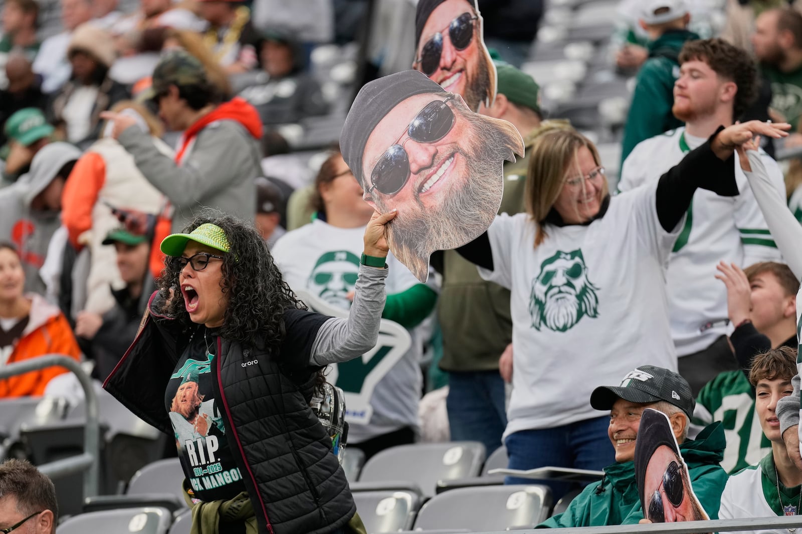 Fans wave large photos of Nick Mangold, former Jets center who recently passed away, before an NFL football game against the Cleveland Browns, Sunday, Nov. 9, 2025, in East Rutherford, N.J. (AP Photo/Seth Wenig)