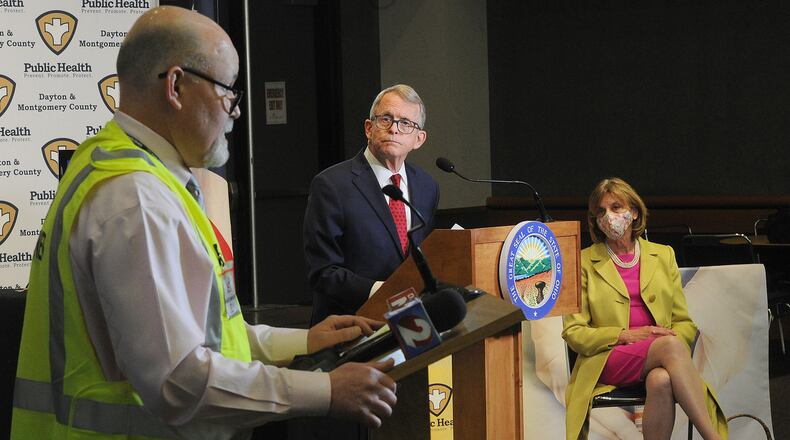 Jeff Cooper, health commissioner for Public Health Dayton Montgomery County, talks with Ohio governor Mike DeWine and first lady Fran DeWine at the Dayton Convention Center Thursday, April 1, 2021. MARSHALL GORBY\STAFF