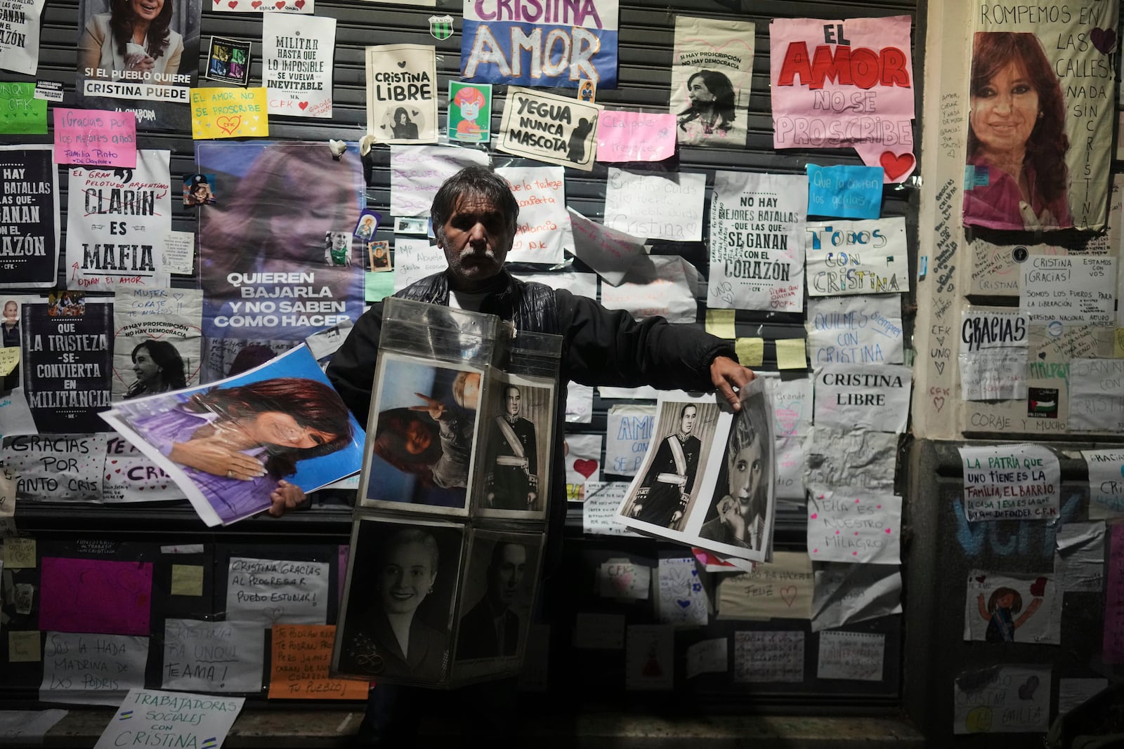 A vendor hawks pictures of former President Cristina Fernandez outside her home, after a federal court granted her request to serve a six-year prison sentence for corruption at her home, in Buenos Aires, Argentina, Tuesday, June 17, 2025. (AP Photo/Natacha Pisarenko)