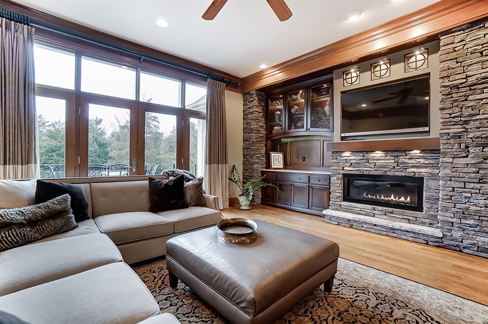 A wall of windows and French doors fill the great room with natural light and allow access to the backyard, balcony deck. A stacked-stone fireplace has built-ins for media display and storage. CONTRIBUTED PHOTO