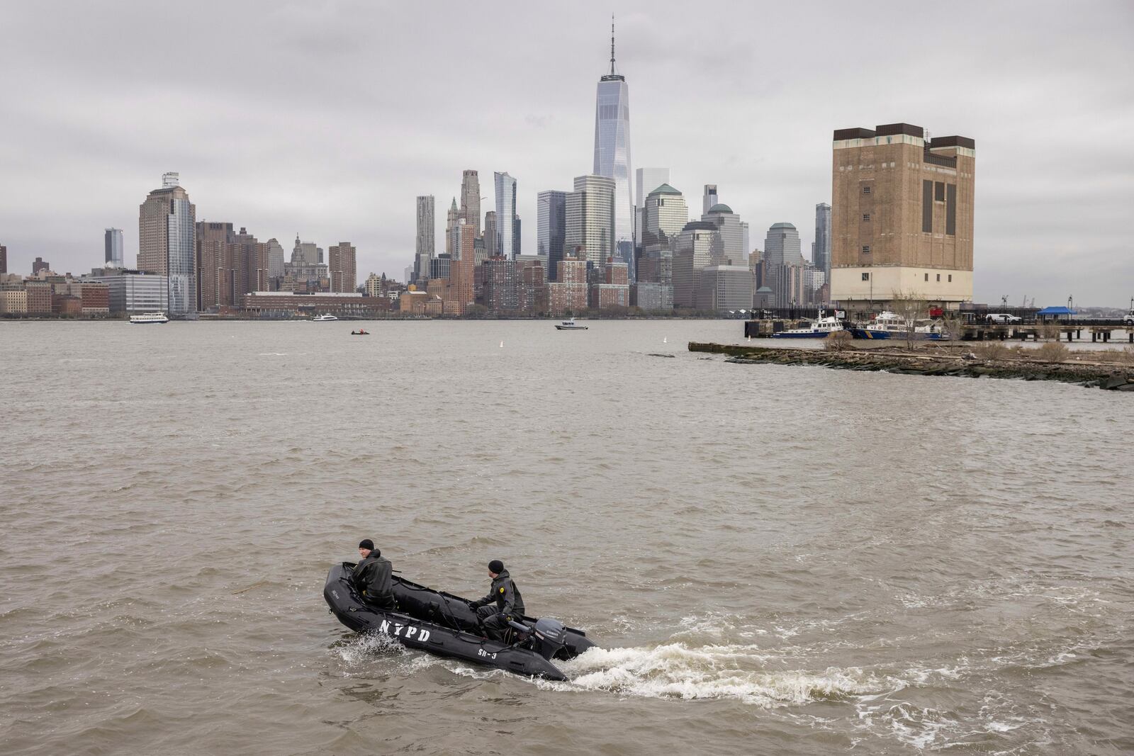 A New York Police Department scuba team looks for debris, Friday, April 11, 2025, where a sightseeing helicopter crashed a day earlier into the Hudson River in Jersey City, N.J. (AP Photo/Yuki Iwamura)